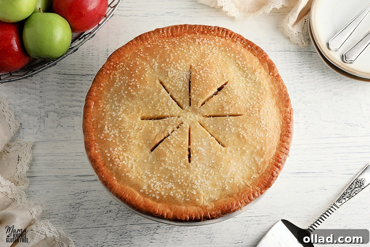 Feast-Worthy Gluten-Free Thanksgiving Desserts 3 gluten-free apple pie with pie cutter, basket of apples, and white plates