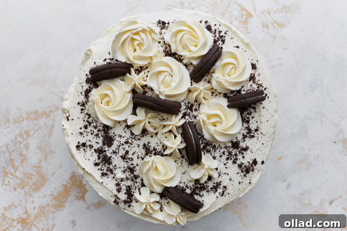 Decadent Gluten-Free Ice Cream Cake 21 Overhead view of a fully decorated gluten-free ice cream cake, topped with piped whipped cream rosettes, crushed cookies, and whole gluten-free sandwich cookies.