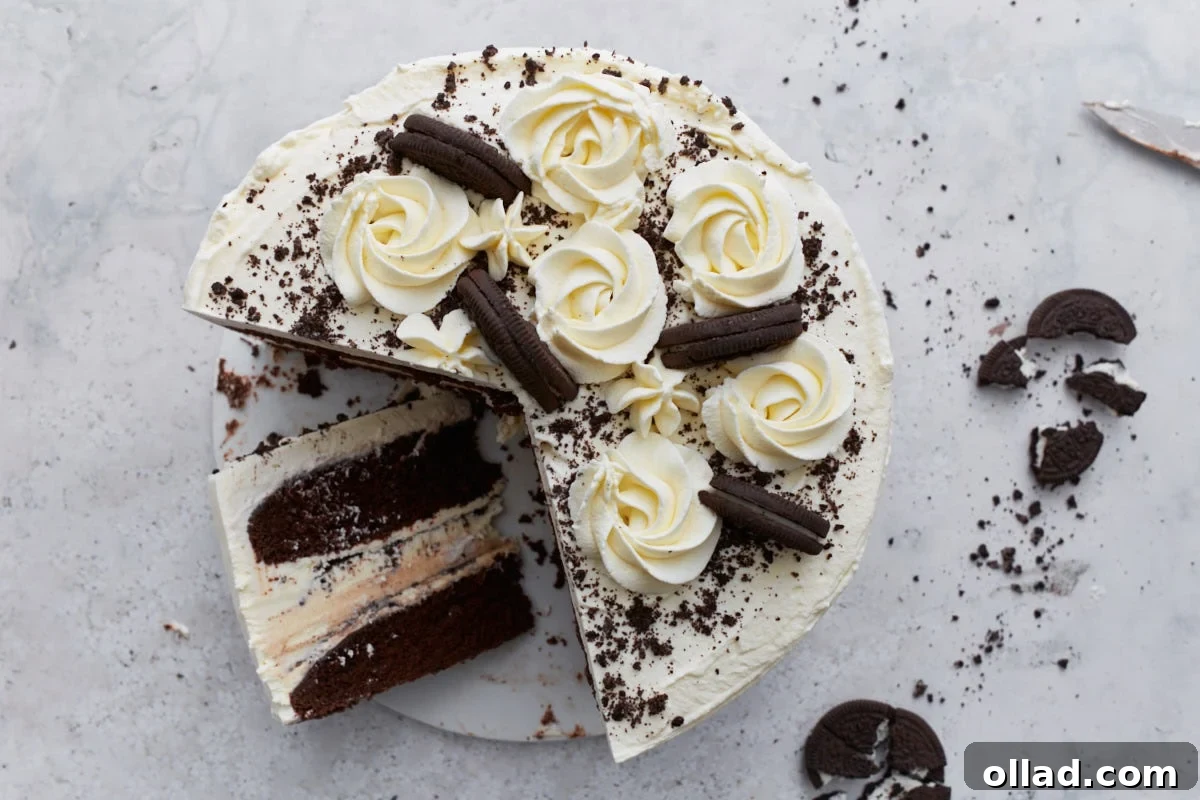 Decadent Gluten-Free Ice Cream Cake 22 A sliced gluten-free ice cream cake showing the interior layers of chocolate cake, ice cream with cookie pieces, and whipped cream frosting, with cookie crumbs scattered on the surface.
