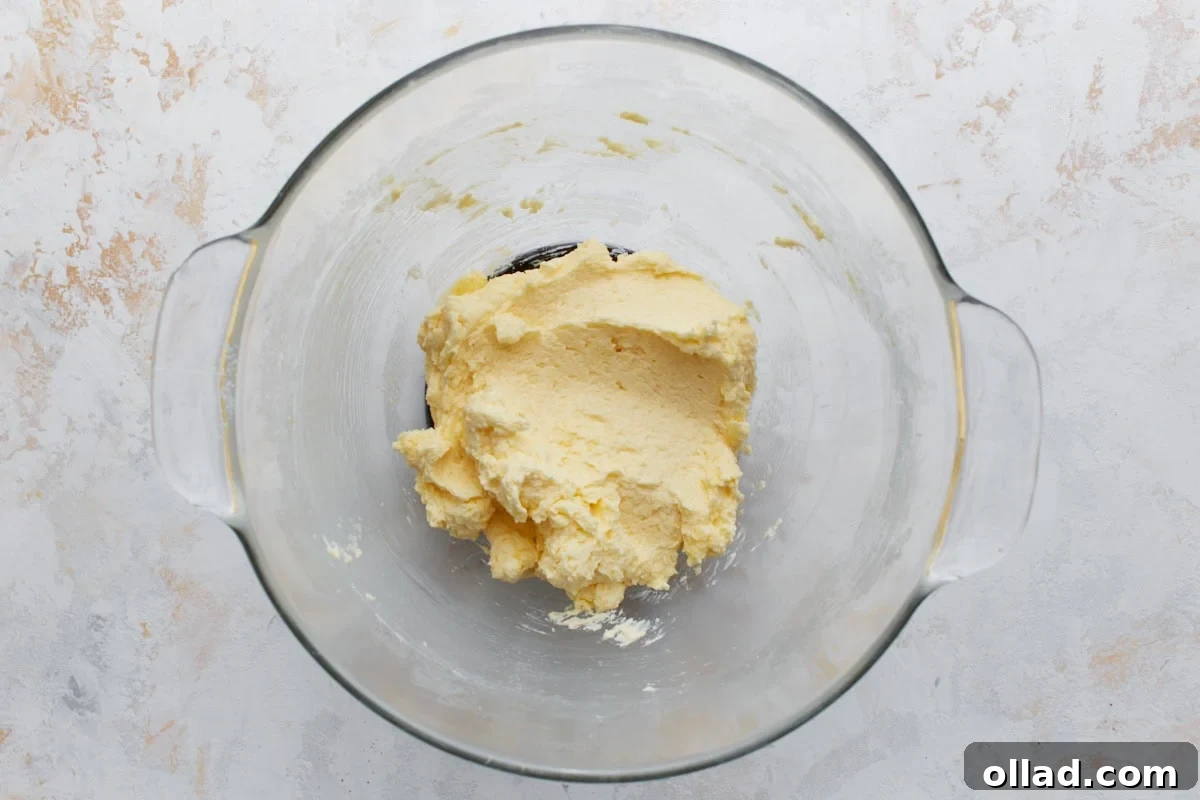 Chewy Gluten-Free Snickerdoodle Delights 6 The smooth, pale yellow cookie batter rests in a glass bowl, showcasing its creamy consistency after the eggs and pure vanilla extract have been thoroughly mixed in, ready for the dry ingredients.