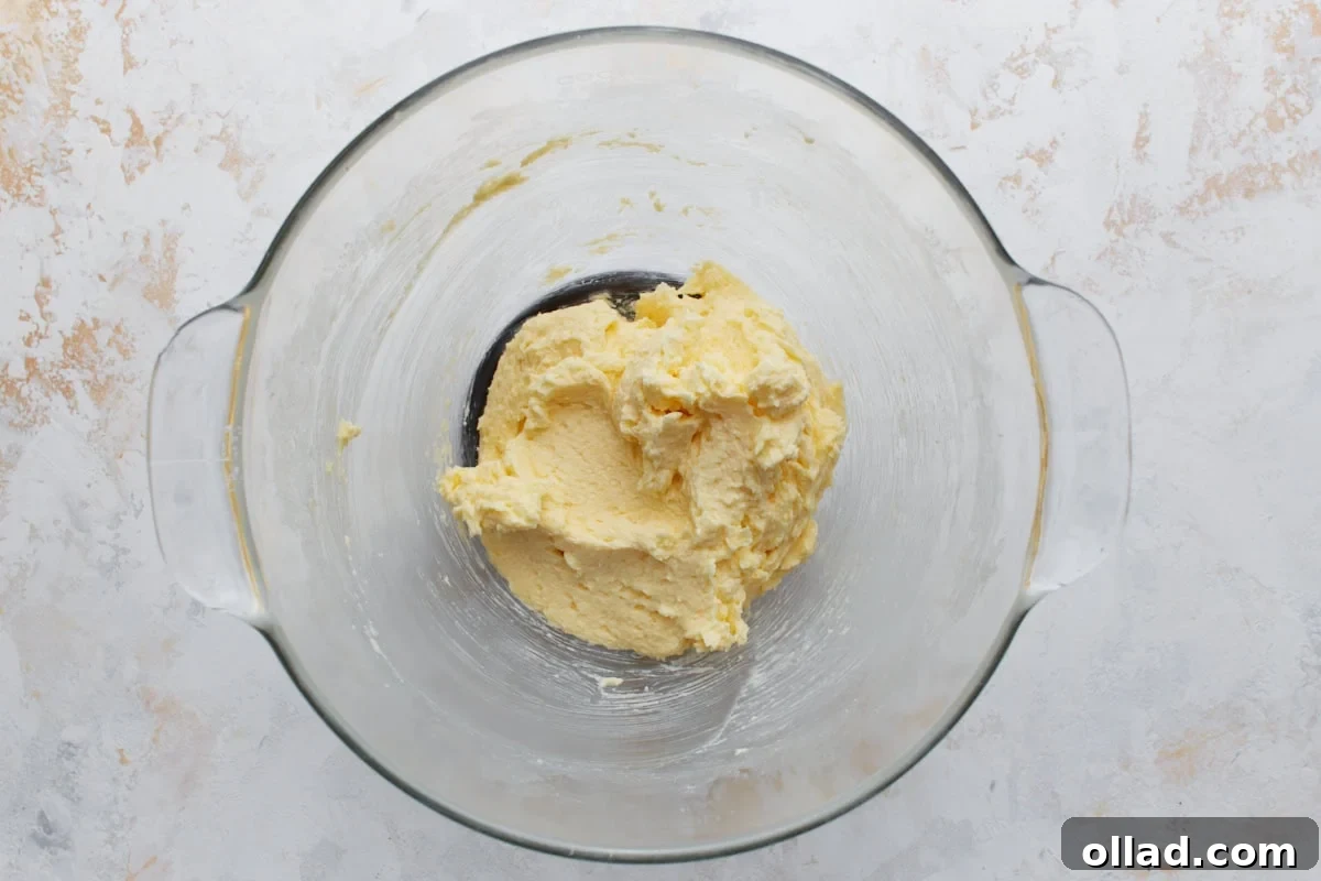 Chewy Gluten-Free Snickerdoodle Delights 7 A light, thick, and evenly whipped butter mixture fills a glass bowl, prepared for the introduction of the gluten-free flour blend and other dry components to form the snickerdoodle dough.