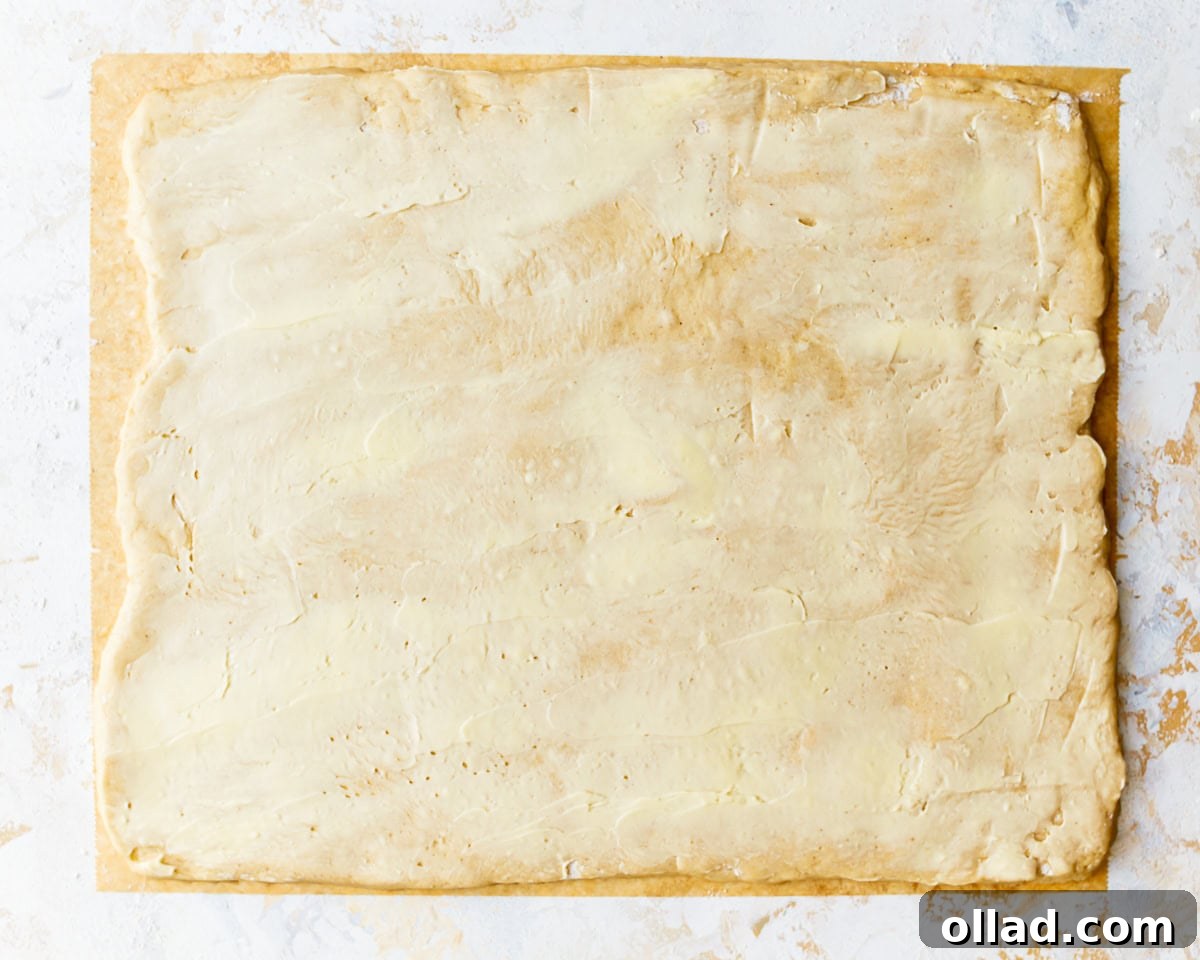 Irresistible Gluten-Free Cinnamon Rolls 14 a buttered rectangle of dough.