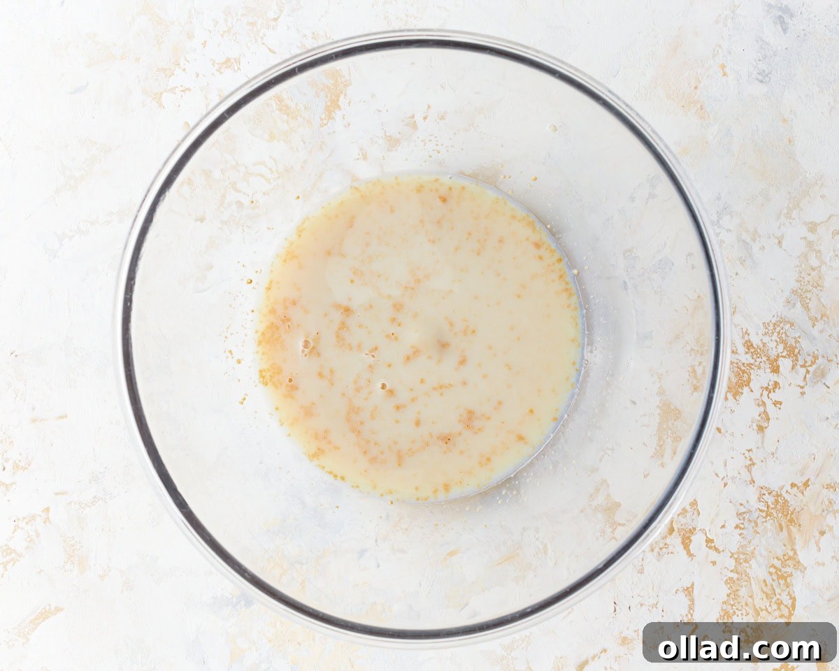 Irresistible Gluten-Free Cinnamon Rolls 5 yeast and milk in a glass bowl.