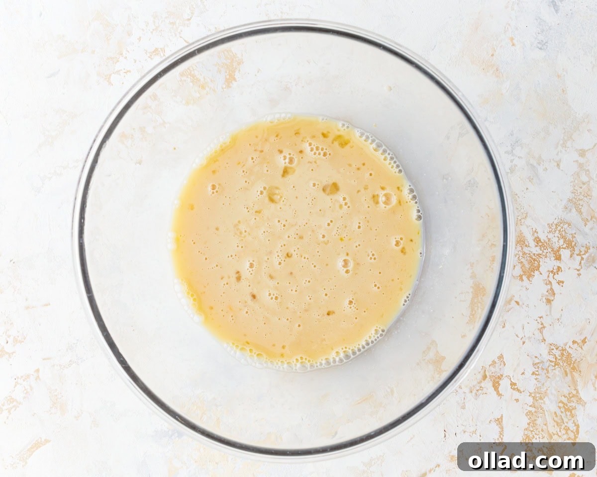 Irresistible Gluten-Free Cinnamon Rolls 6 foamy yeast in liquid in a glass bowl.