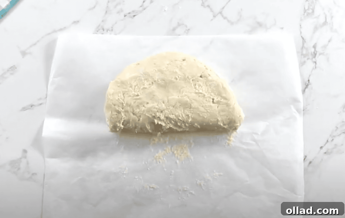 The dough is folded in half on a floured surface during the layering step.