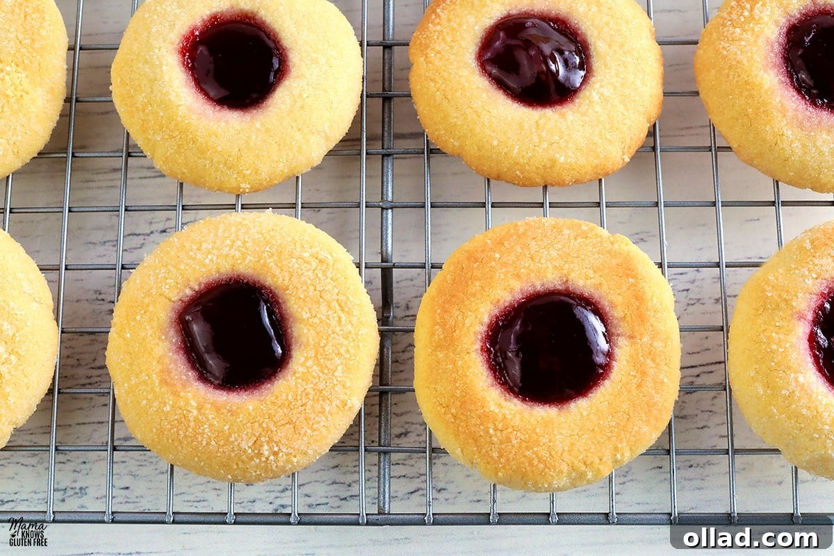Freshly baked gluten-free thumbprint cookies cooling on a wire rack.