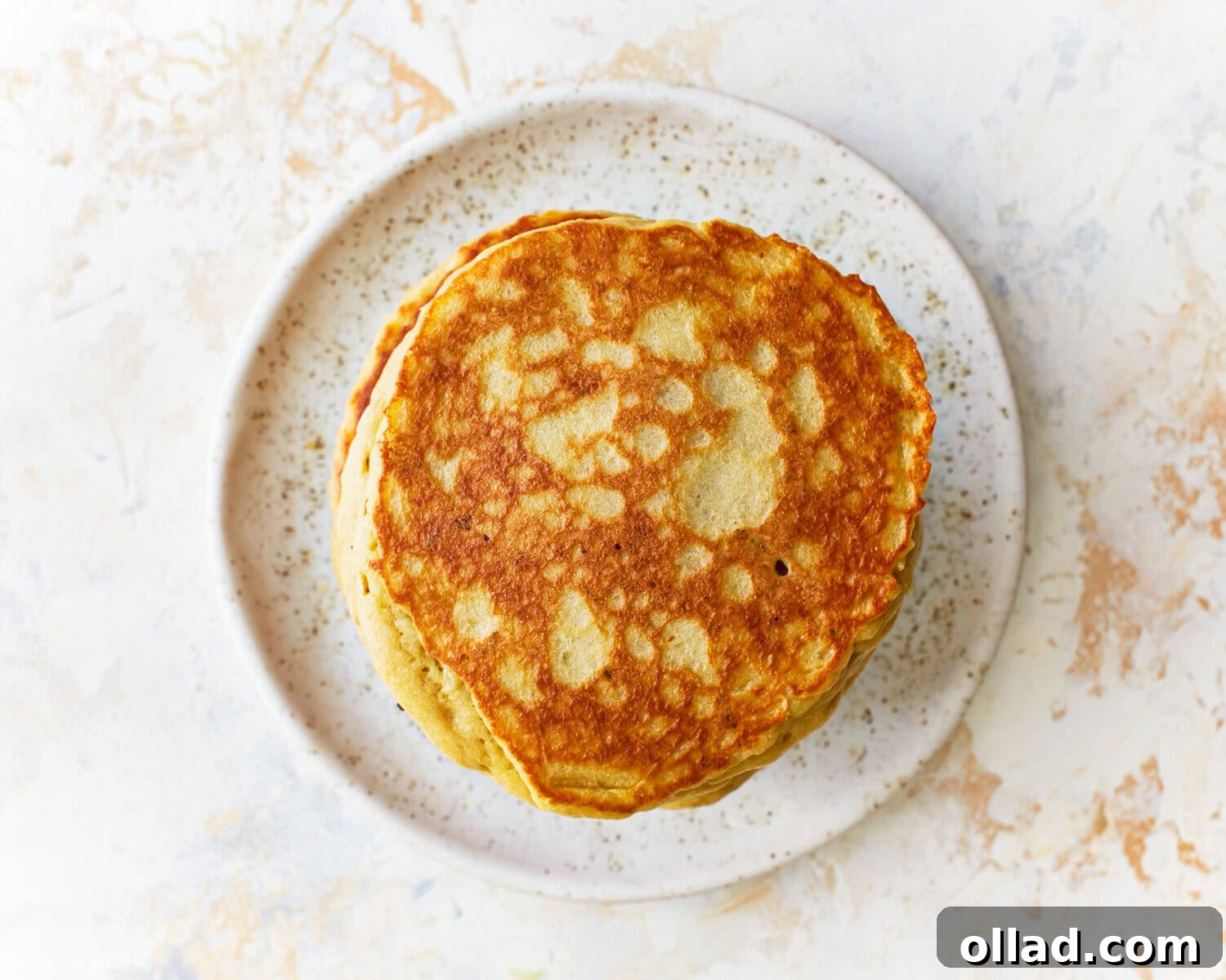 A delectable plate of freshly made almond flour pancakes, neatly stacked and waiting to be adorned with toppings.