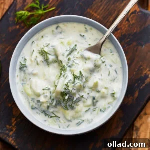 A close up of a fork taking some dairy-free tzatziki from a bowl.