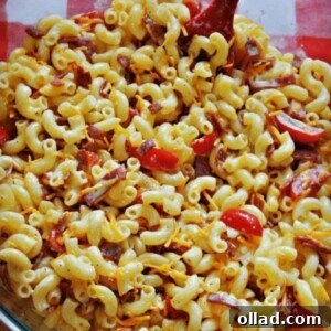 Gluten-free macaroni salad in a glass bowl with bacon, tomato, and cheese