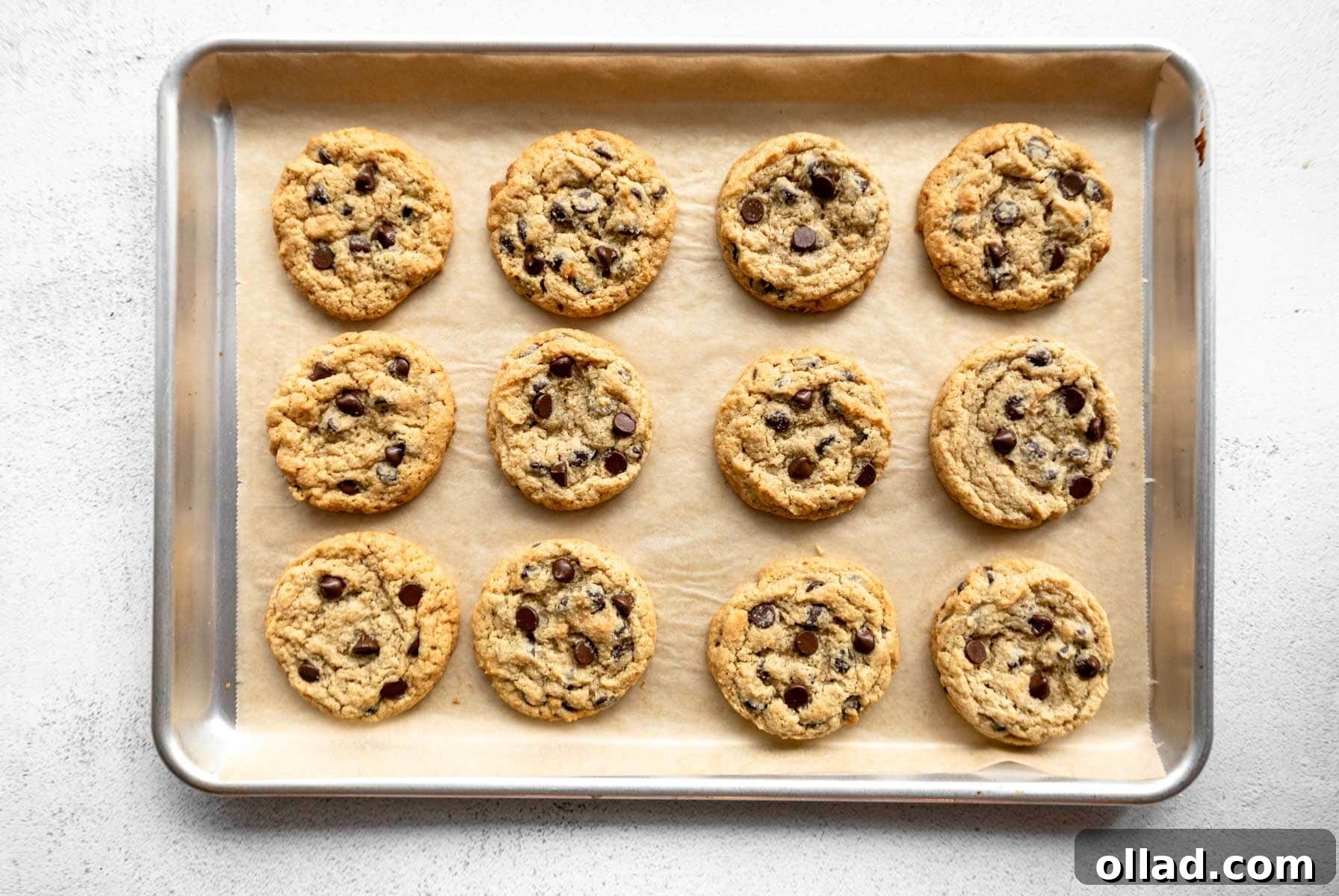 Freshly baked almond flour chocolate chip cookies on a baking sheet, golden brown at the edges.