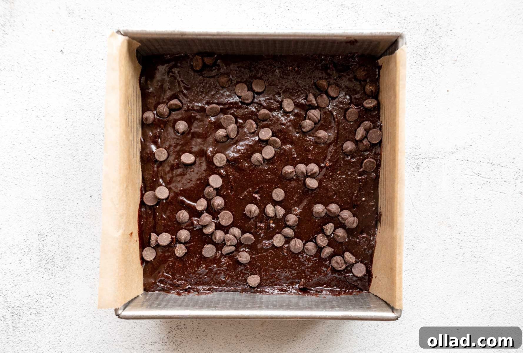 Decadent Almond Flour Fudge Brownies 9 Almond flour brownie batter in a baking pan topped with chocolate chips