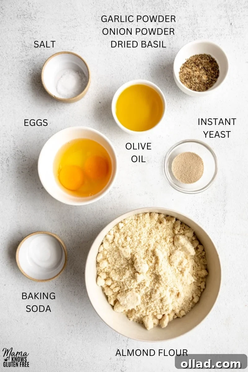 Ingredients for Gluten-Free Almond Flour Pizza Crust laid out in bowls, cups and measuring spoons on a wooden surface.