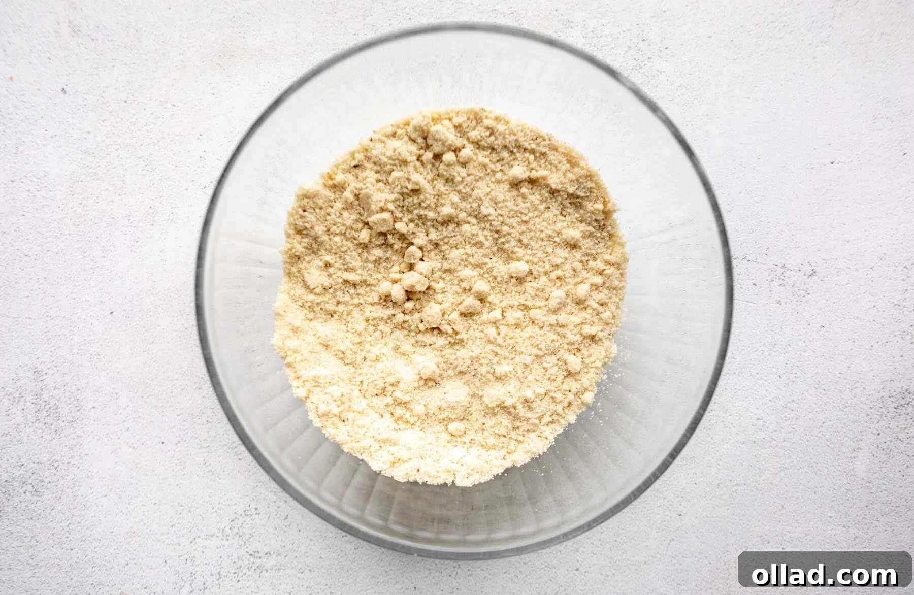 Almond flour in a clear glass bowl, ready for mixing.
