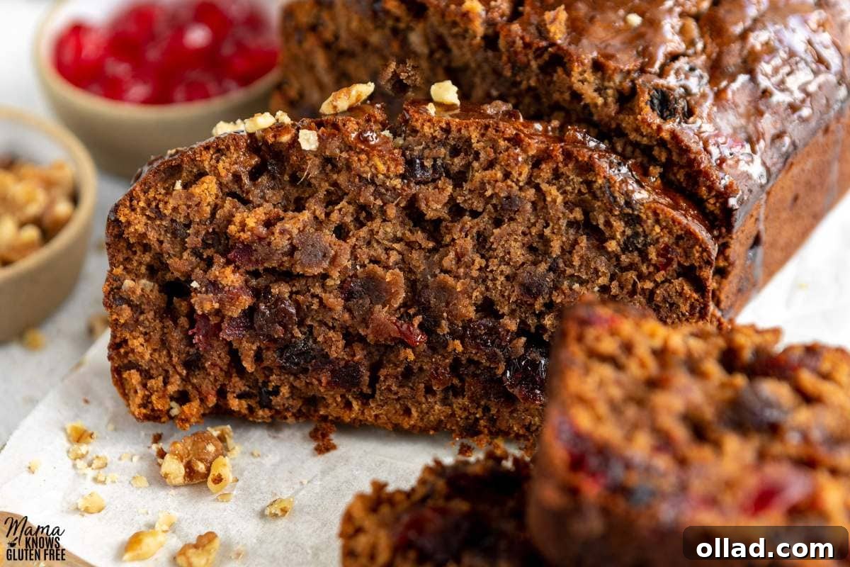 Deliciously Flourless Fruitcake 2 Close up of a slice of Gluten-Free Fruit Cake with candied cherries in the background.