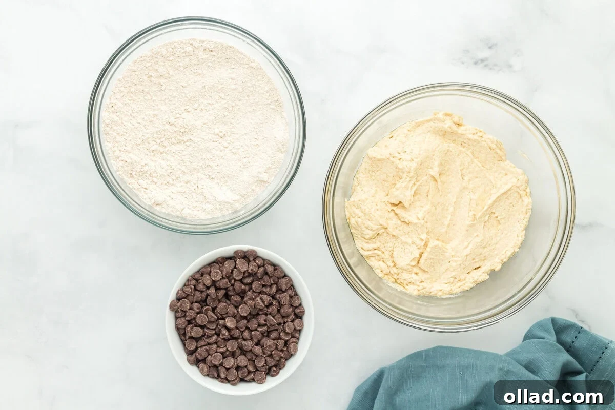 Eggs and vanilla extract being beaten into the butter and sugar mixture for oat flour chocolate chip cookies.