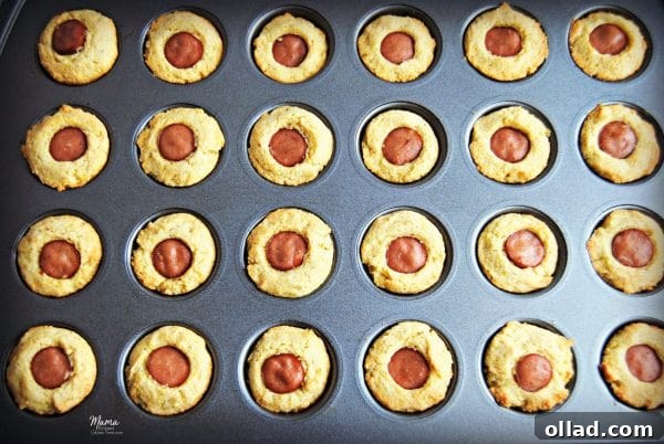 Close-up of Gluten-Free Mini Corn Dog Bites fresh out of the oven, showcasing the crispy cornbread coating and hot dog pieces.