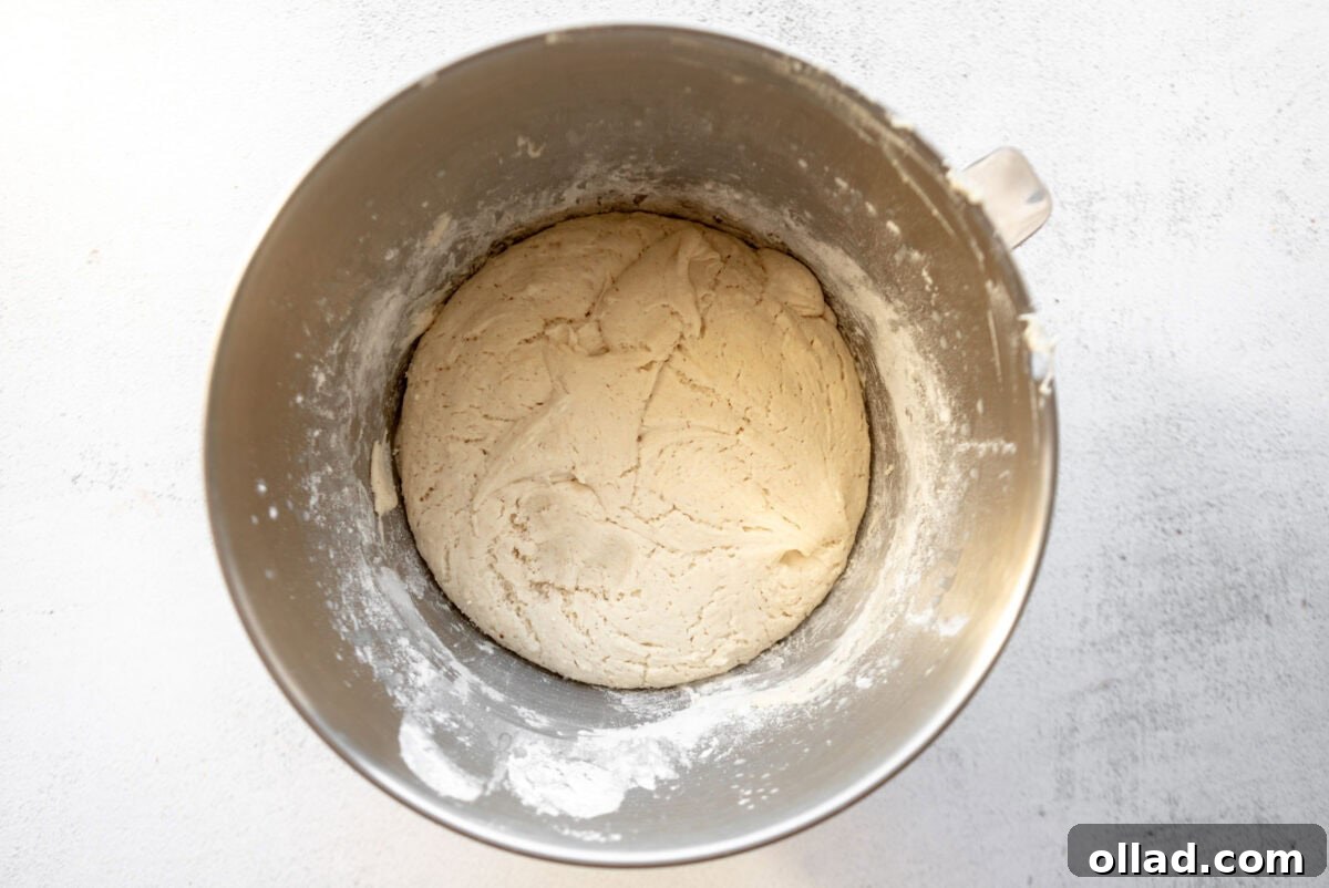 Gluten-free English muffin dough after the first rise, in a stand mixer bowl.