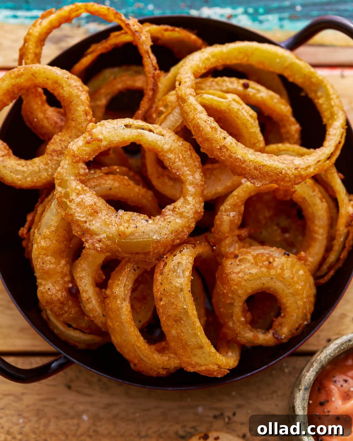 Crispy Gluten-Free Onion Rings 2 A beautifully presented black bowl overflowing with golden, ultra-crispy gluten-free onion rings, perfectly fried and ready to be enjoyed.