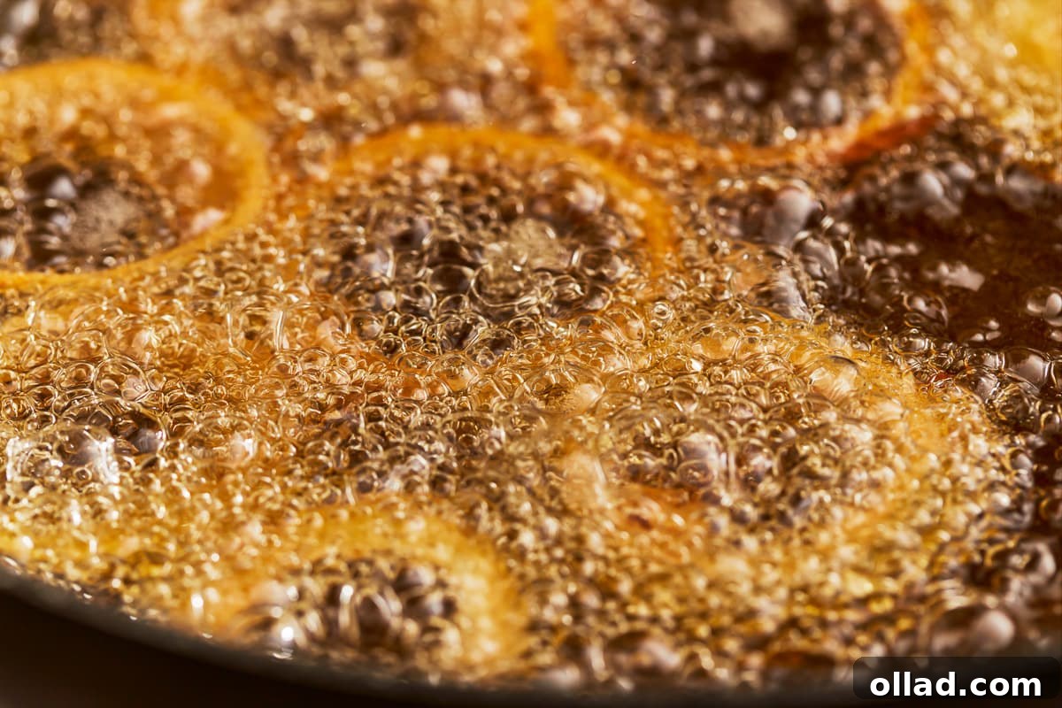 Crispy Gluten-Free Onion Rings 10 Gluten-free onion rings actively sizzling and turning golden brown as they fry in a pot of hot oil.
