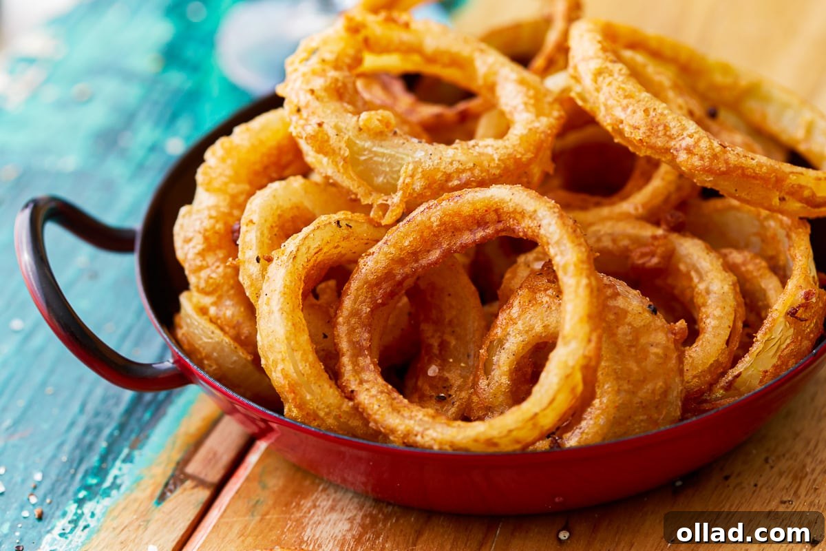 Crispy Gluten-Free Onion Rings 4 A charming rustic red cast iron dish filled to the brim with perfectly golden and crispy gluten-free onion rings, ready for serving.