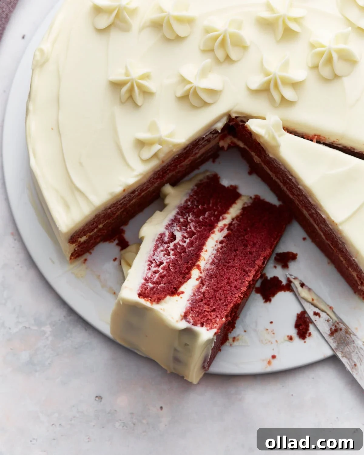 Irresistible Gluten-Free Cake Secrets 12 Gluten-free red velvet cake with cream cheese frosting, decorated with piped flowers, and a slice partially removed