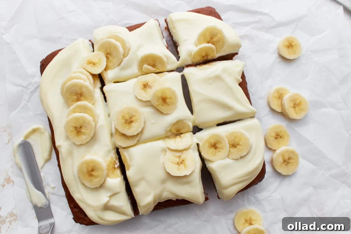 Irresistible Gluten-Free Cake Secrets 7 Gluten-free banana cake sliced and topped with cream cheese frosting and fresh banana slices on white parchment paper