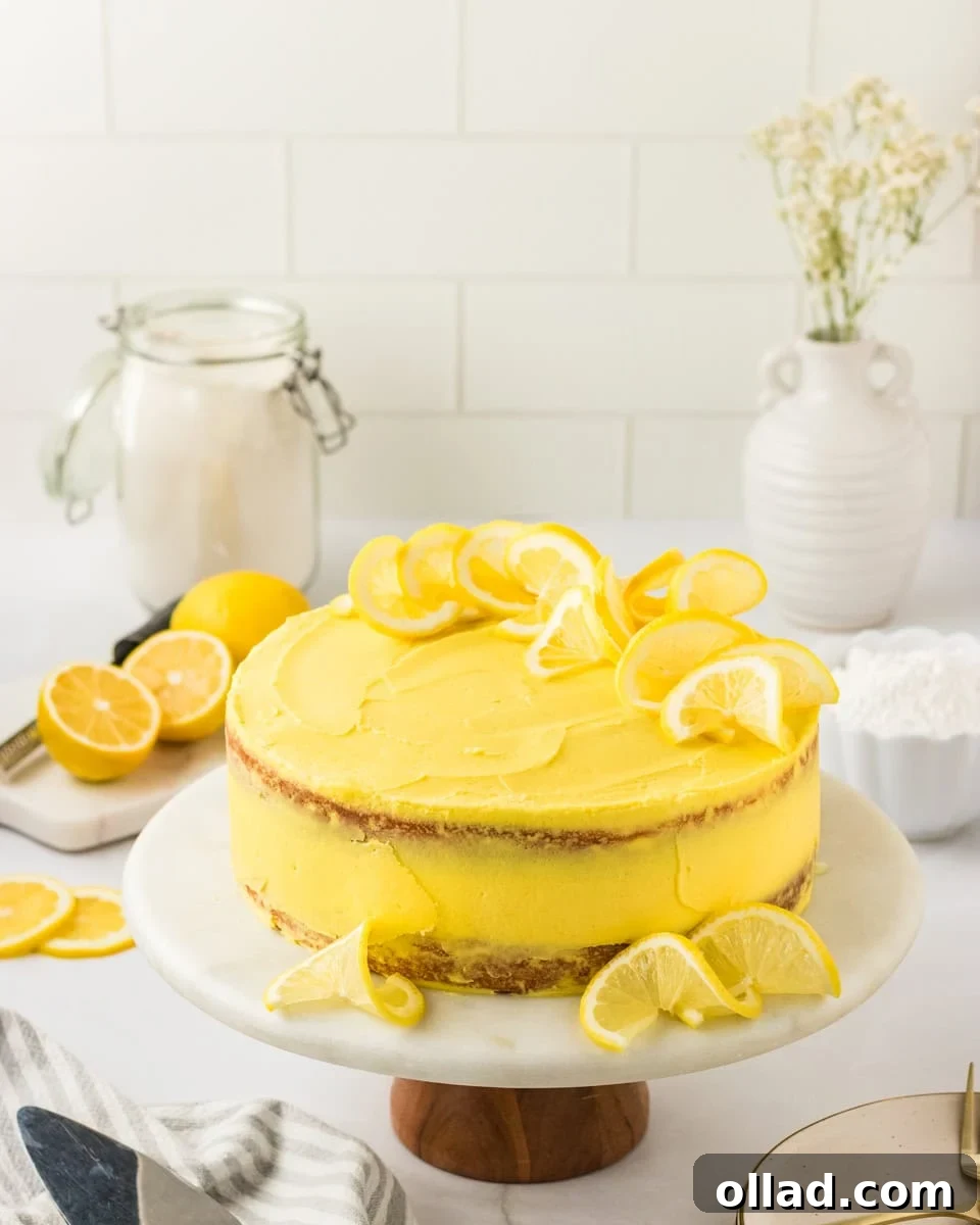 Irresistible Gluten-Free Cake Secrets 10 A frosted gluten-free lemon cake on a marble cake stand, decorated with lemon slices on top and around the base. The cake has a bright yellow frosting and a rustic, semi-naked finish. Fresh lemons, a jar of flour, and white ceramic vases are styled in the background.