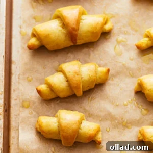 Close-up of baked gluten-free crescent rolls, showing their flaky texture and golden-brown crust.