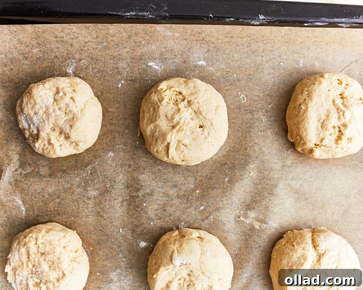 shaped gluten-free hamburger bun dough on a baking sheet.
