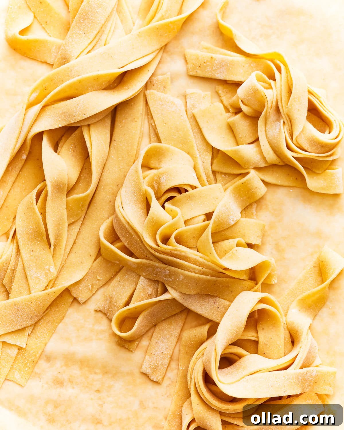 Freshly made gluten-free pasta resting on parchment paper, ready to be cooked.