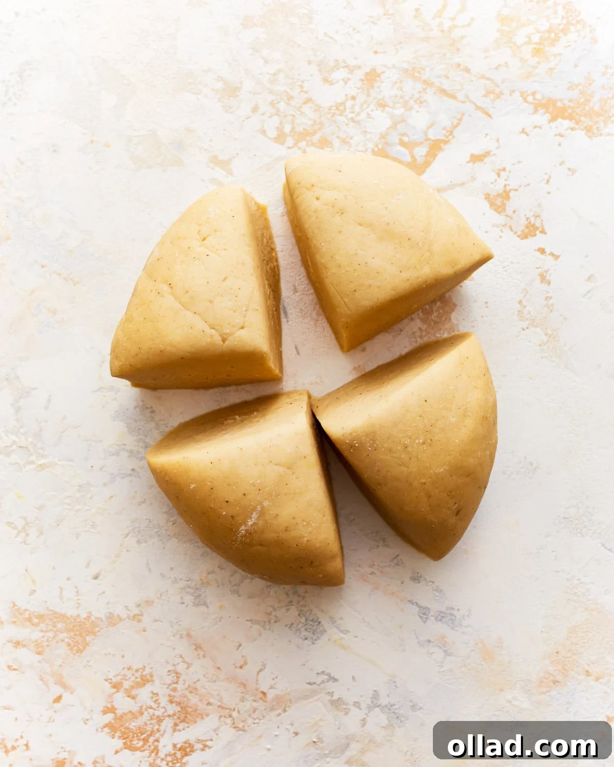 Gluten-free pasta dough divided into four equal portions on a cutting board.