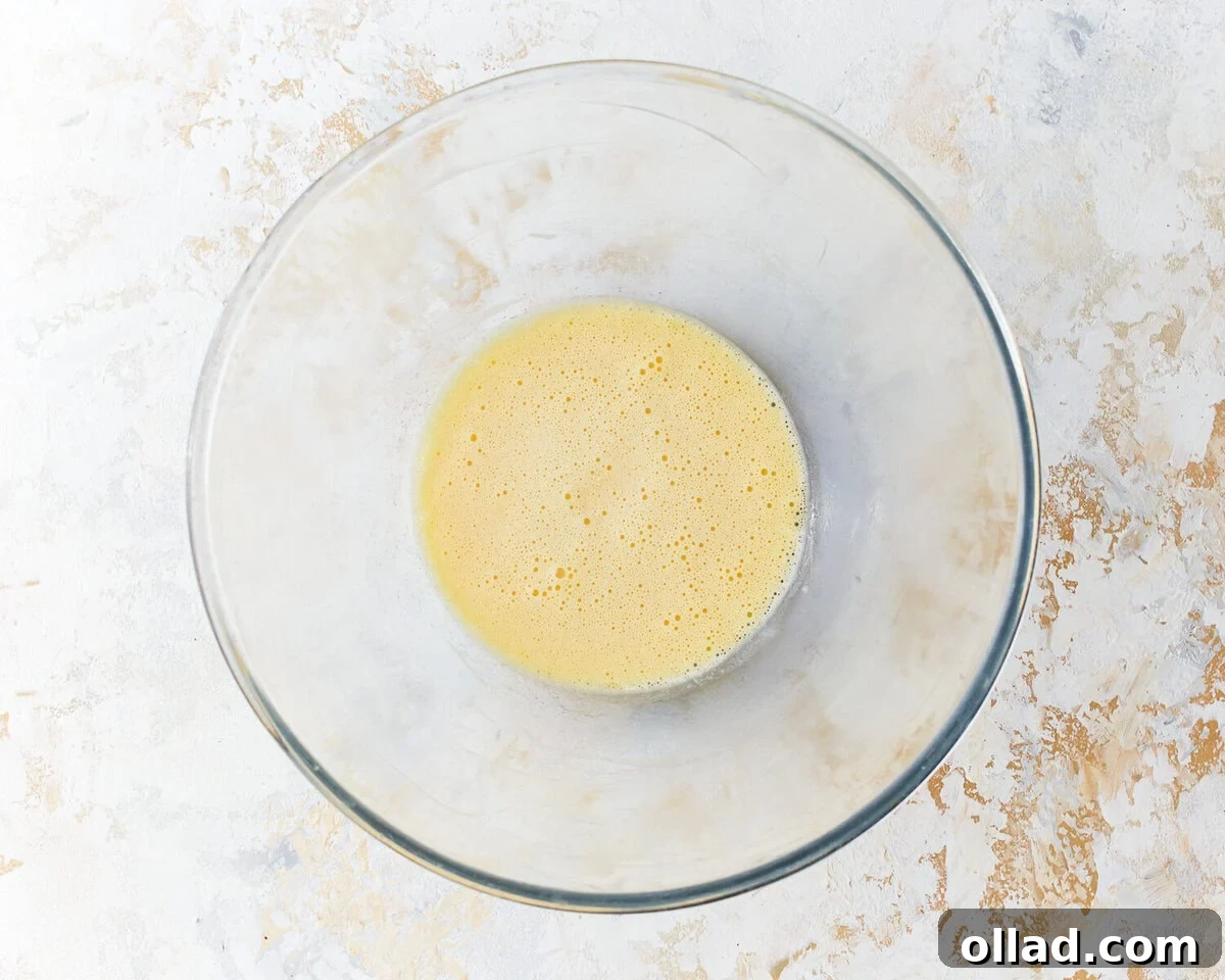 Smooth and creamy egg yolk mixture with softened cream cheese and sea salt in a separate glass bowl.
