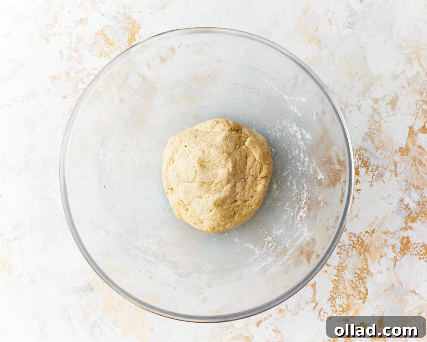 Dough for almond flour tortillas in a glass mixing bowl, just after combining wet and dry ingredients and being kneaded.