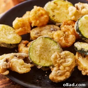 A plate of vegetables and shrimp cooked in a gluten free tempura batter.
