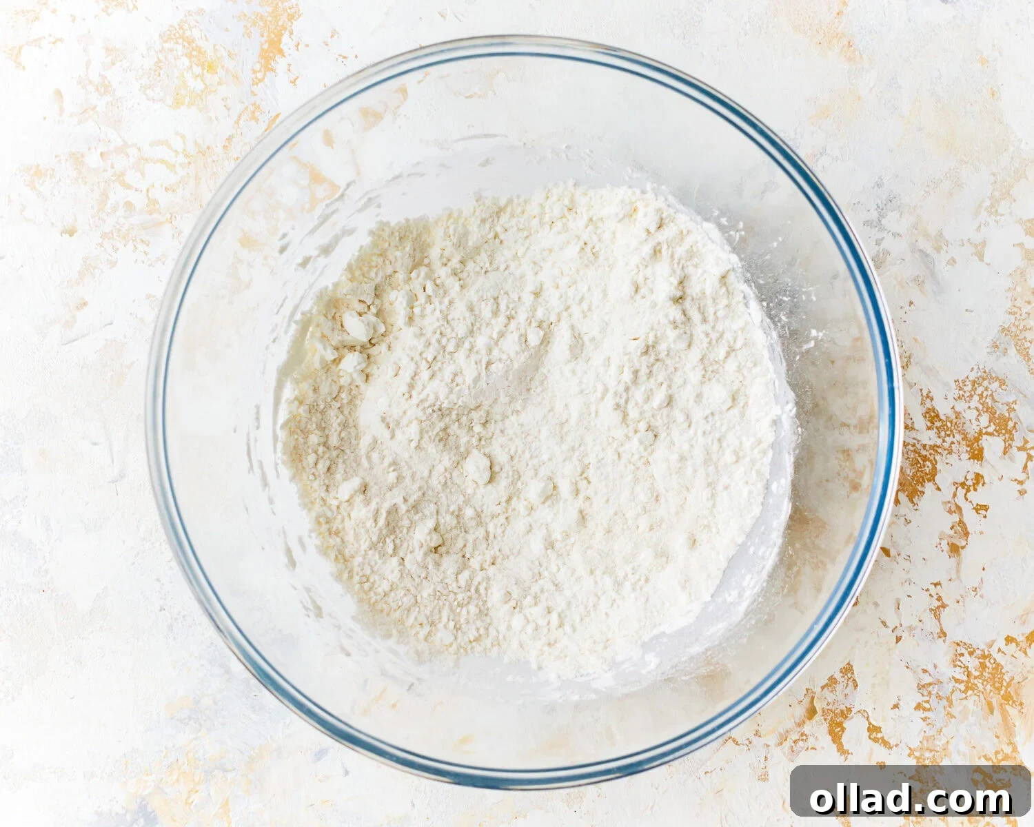 The dry ingredients for gluten free tempura batter, including white rice flour, corn starch, salt, and baking powder, perfectly mixed in a large bowl.