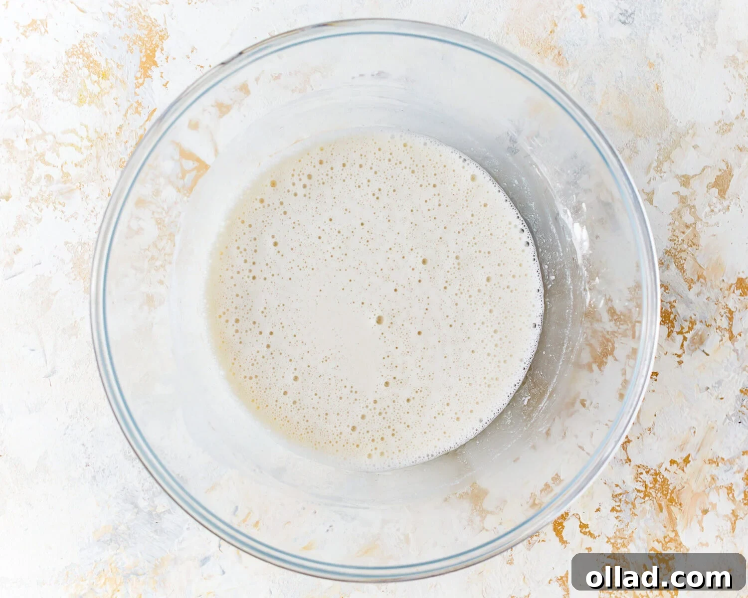 Overhead view of gluten free tempura batter being whisked in a mixing bowl with cold club soda.