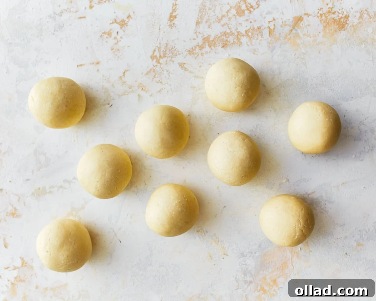 Individual balls of pandebono bread dough, shaped to about the size of a golf ball, ready for baking.