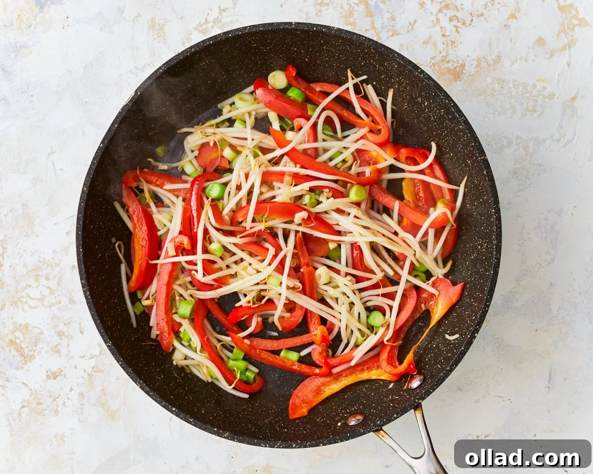 Bean sprouts, bell pepper, green onions, and garlic in a skillet for gluten-free pad thai