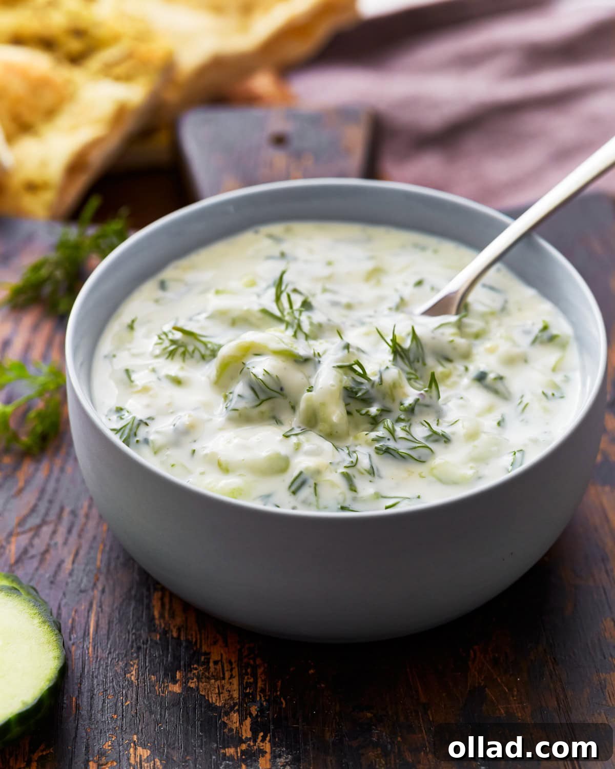 Side view of a bowl of dairy-free tzatziki topped with fresh dill.
