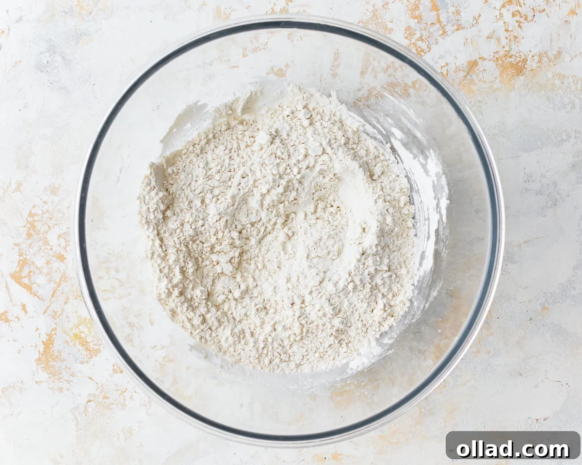 Dry ingredients for gluten-free egg noodles in a clear glass mixing bowl, perfectly combined.