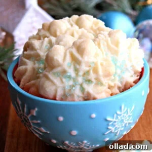 blue snowflake bowl of gluten-free almond spritz cookies with Christmas decorations in the background