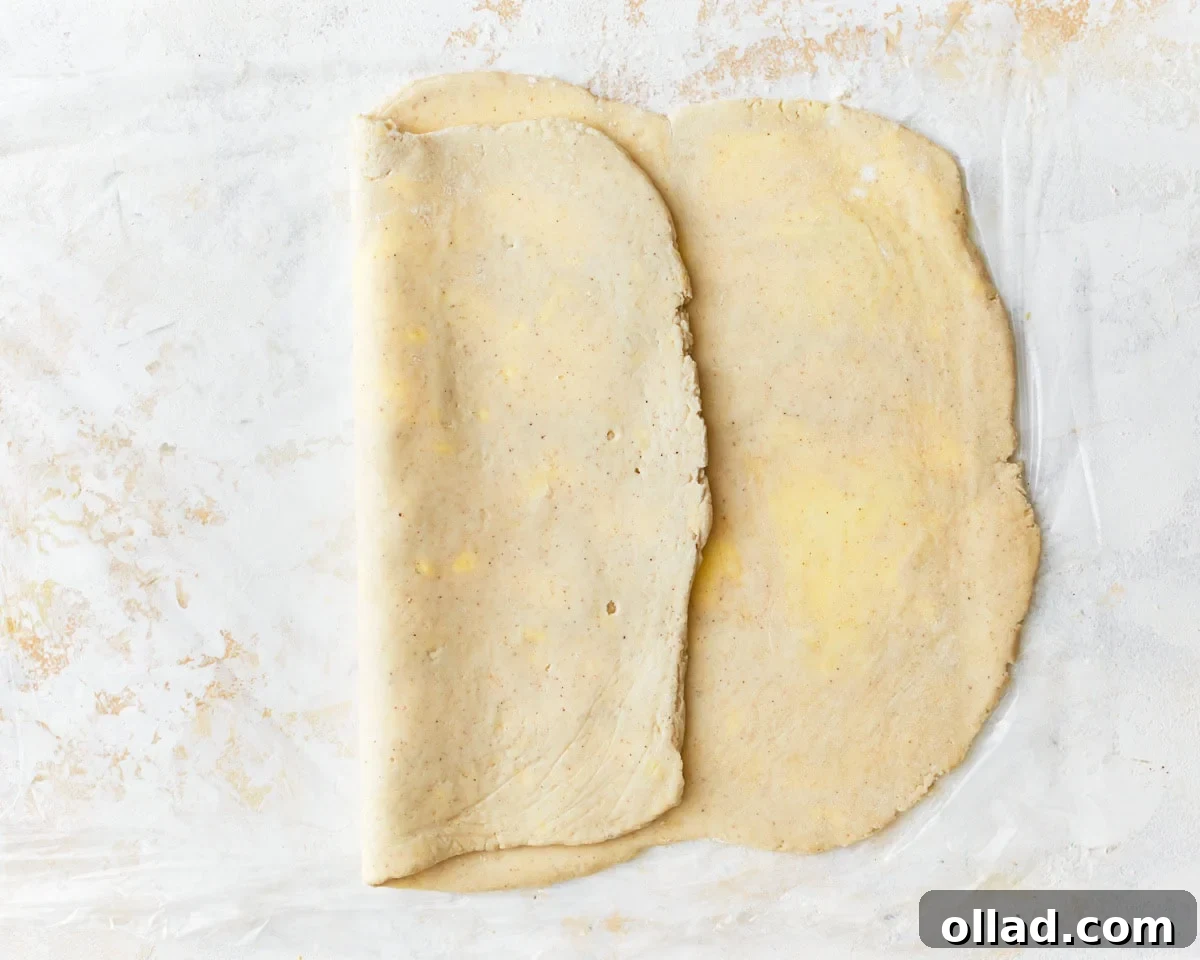 Unbelievably Flaky Gluten-Free Puff Pastry 15 Gluten-free puff pastry dough folded halfway onto itself, preparing for the final fold.