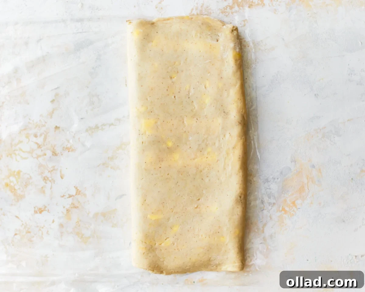 Unbelievably Flaky Gluten-Free Puff Pastry 16 Gluten-free puff pastry dough fully folded into a rectangle, displaying visible butter flecks.