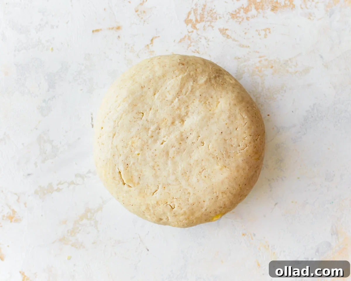 Unbelievably Flaky Gluten-Free Puff Pastry 8 A smooth, cohesive ball of gluten-free puff pastry dough on a floured surface.