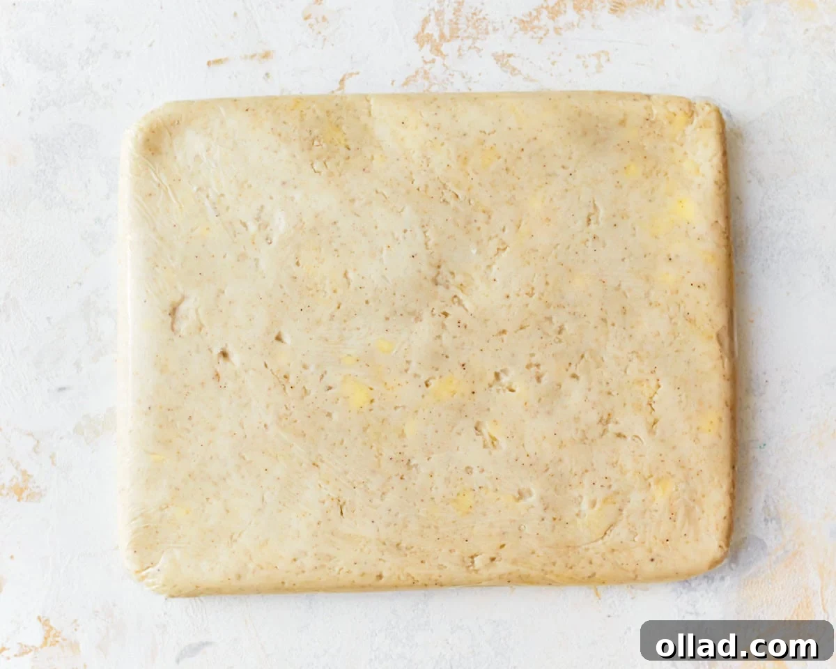 Unbelievably Flaky Gluten-Free Puff Pastry 9 Gluten-free puff pastry dough flattened into a rectangle and wrapped in plastic wrap.