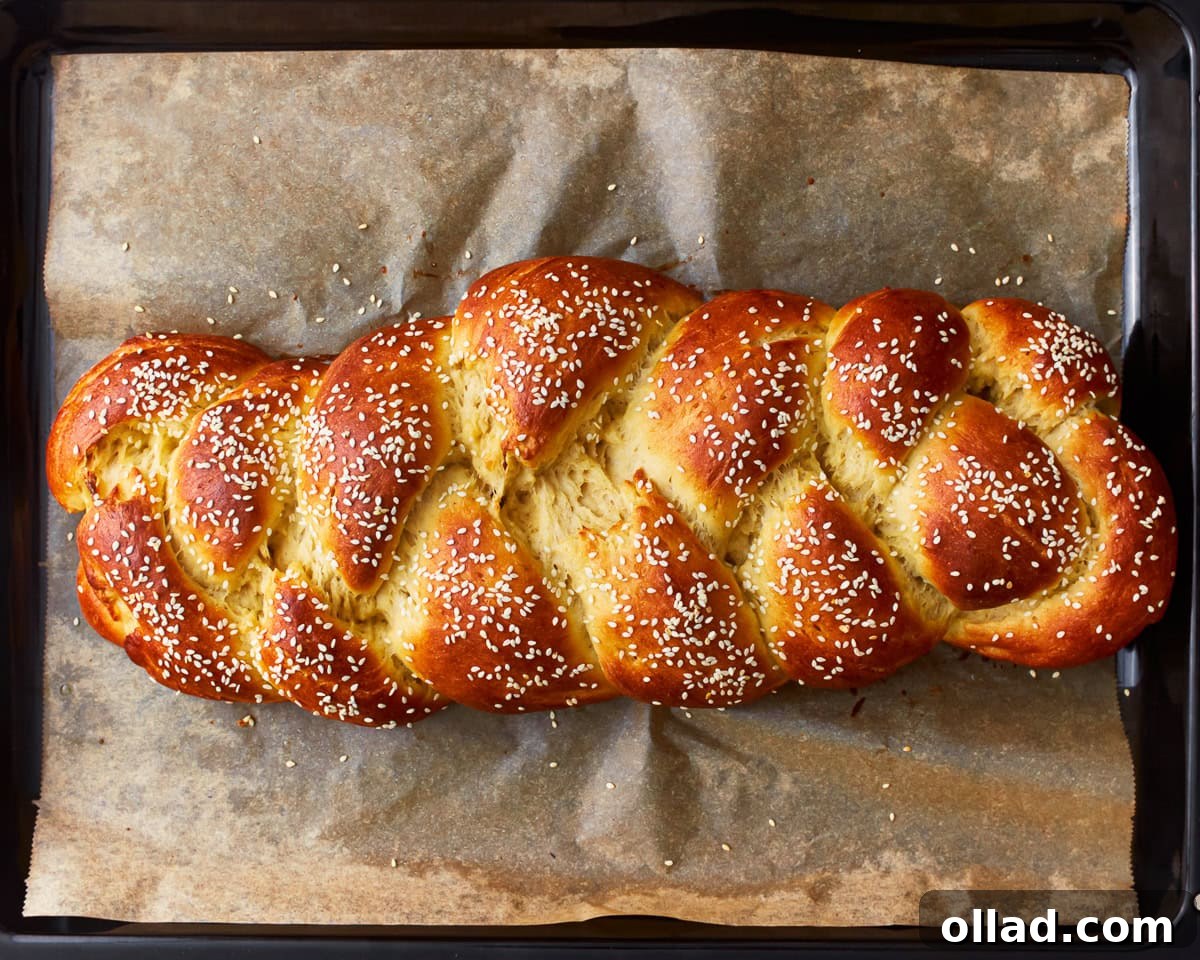 Freshly baked gluten-free challah bread on a parchment lined baking tray.
