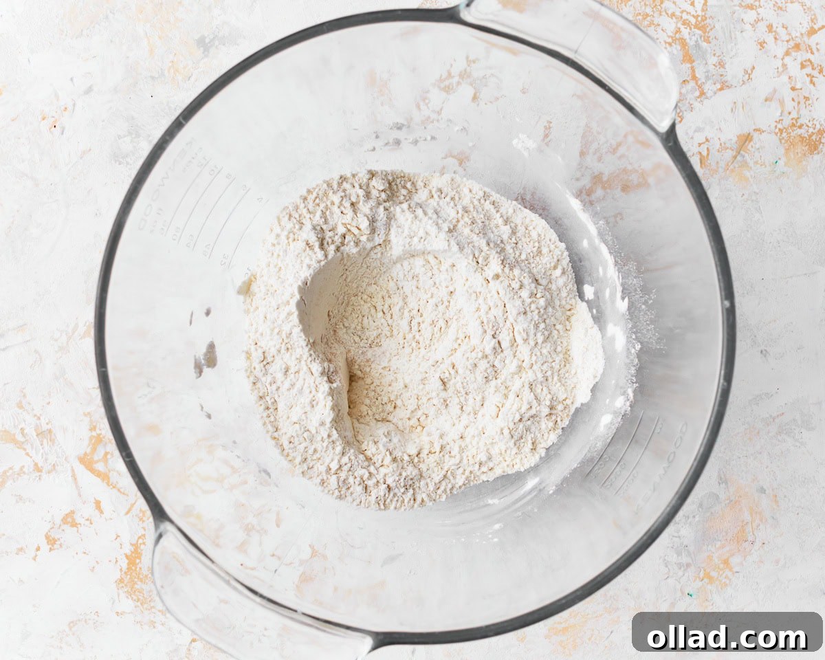 Dry ingredients for gluten-free challah bread in a glass mixing bowl.