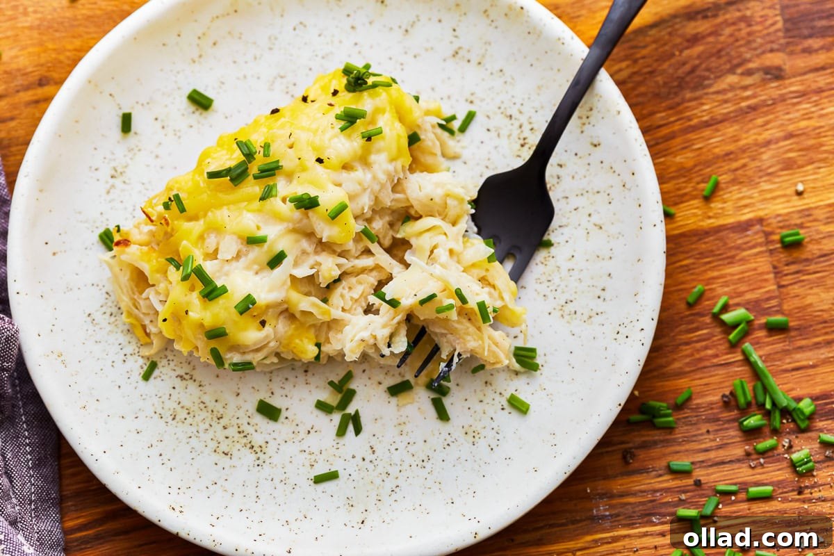 Overhead view of a plate of dairy-free cheesy potatoes with a fork.