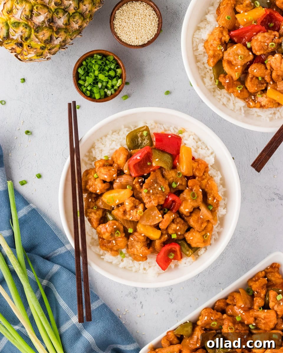 Irresistible Gluten-Free Sweet and Sour Chicken 5 overhead view of sweet and sour chicken and veggies over rice in white bowl with chopsticks resting on the side of the bowl
