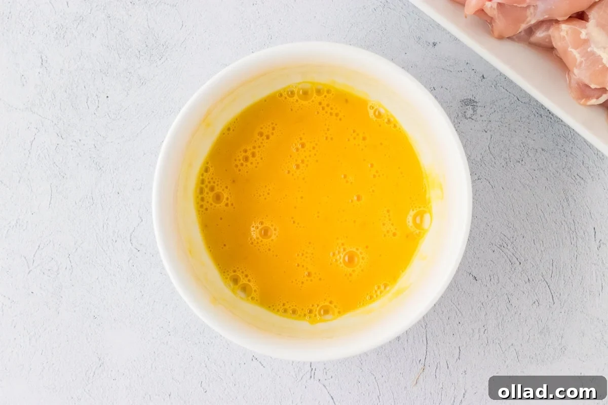 Irresistible Gluten-Free Sweet and Sour Chicken 9 whisked eggs in a white bowl